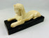 Early 20th century carved sphinx figure inspired by ancient Egyptian art, mounted on black wooden base