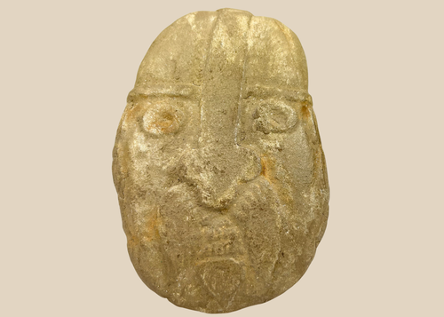 Carved stone warrior effigy head with helmet and bold facial features