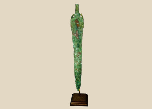 Ancient Bronze Age blade from the Caspian region, circa 2000–1000 BCE, with tapered elongated form, two perforations near the hilt, and rich green patina, mounted on a custom stand.