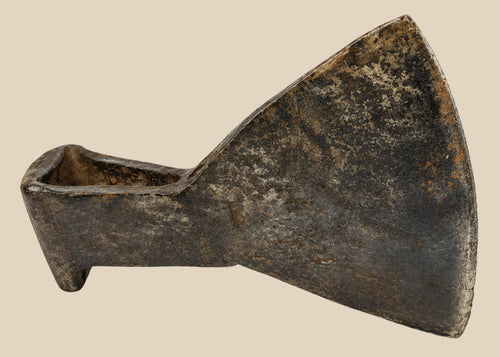 18th-century cast iron axe head from Europe or Colonial America, wedge-shaped with trapezoidal blade, triangular socket, faint punched motif, aged patina, and oxidation, reflecting historical tool craftsmanship.