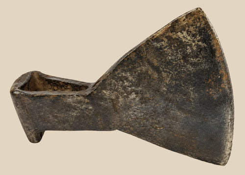 18th-century cast iron axe head from Europe or Colonial America, wedge-shaped with trapezoidal blade, triangular socket, faint punched motif, aged patina, and oxidation, reflecting historical tool craftsmanship.