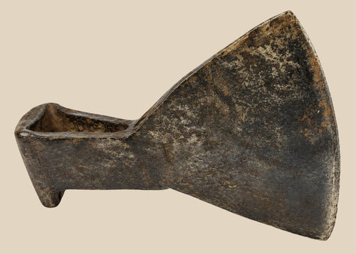 18th-century cast iron axe head from Europe or Colonial America, wedge-shaped with trapezoidal blade, triangular socket, faint punched motif, aged patina, and oxidation, reflecting historical tool craftsmanship.