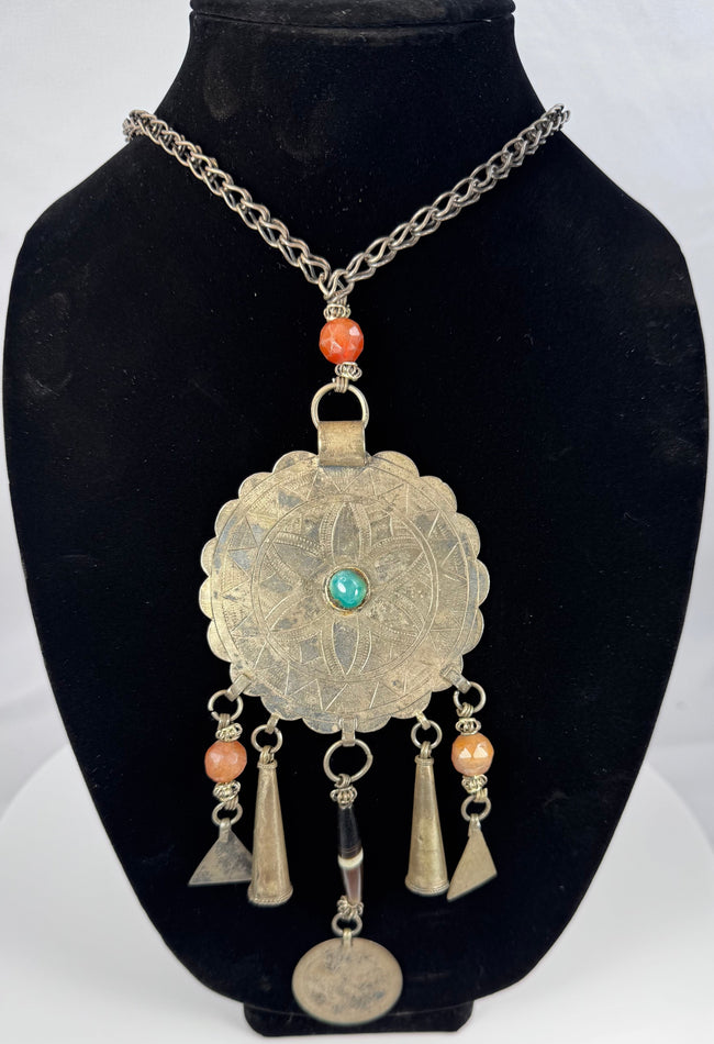 Tribal necklace with turquoise-coloured centre, orange beads, and geometric decoration