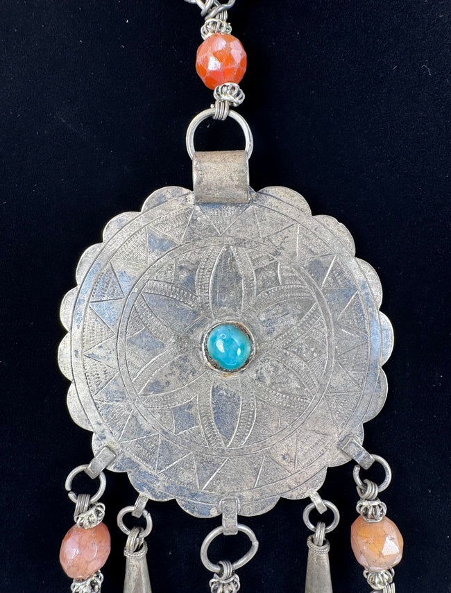 Close-up of six-petalled floral engraving on a large Afghan circular pendant