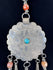Close-up of six-petalled floral engraving on a large Afghan circular pendant