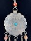 Close-up of six-petalled floral engraving on a large Afghan circular pendant