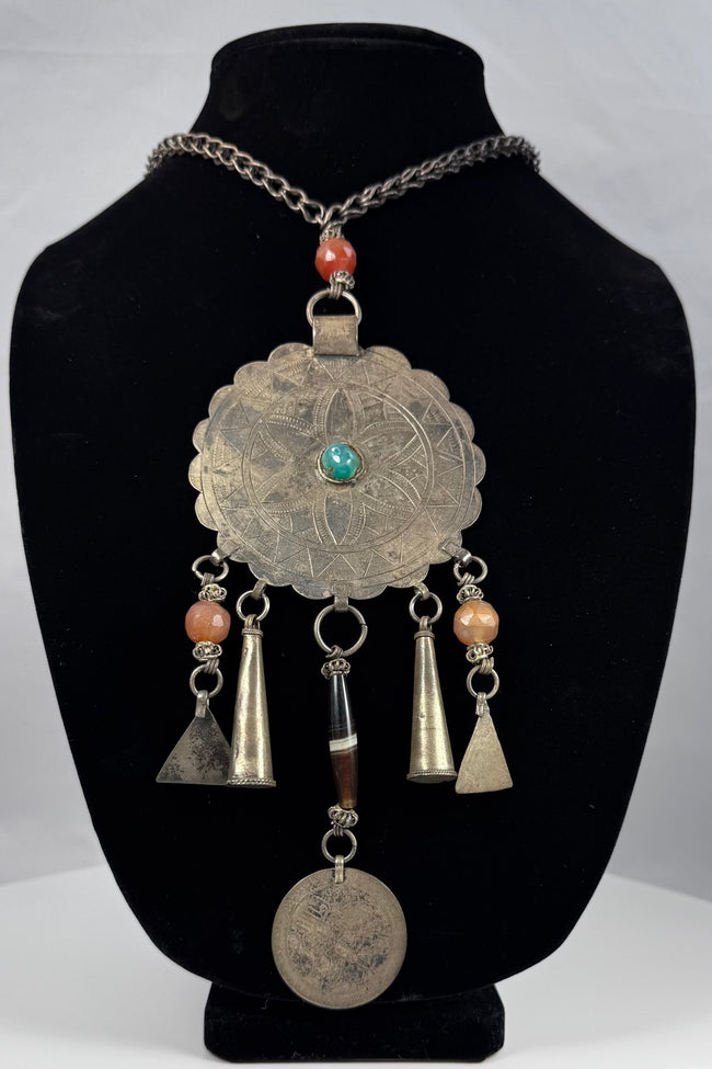 Large scalloped tribal pendant with punched borders and hand-fashioned suspension rings