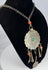 Reverse view of tribal metal pendant showing oxidation, rubbing, and handmade construction
