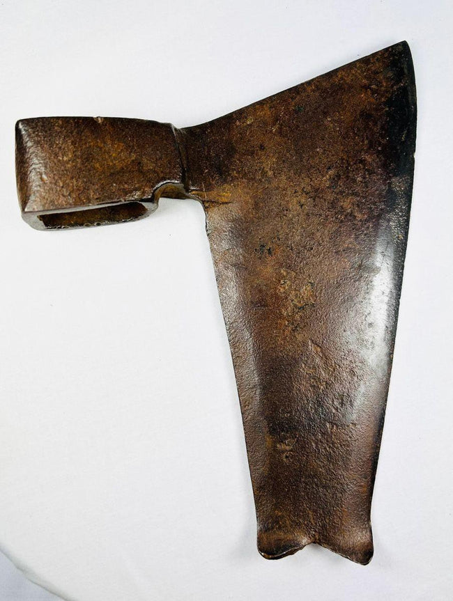 Side view of antique wrought iron axe head showing broad tapering blade and fishtail base