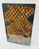 Detailed view of Andean textile fragment featuring yellow, brown, and red woven squares.