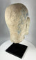 Historic Chinese temple sculpture fragment of a Luohan head with traces of painted decoration.