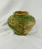 Close-up of green-glazed Chinese pottery jar showing relief designs from the Han Dynasty.