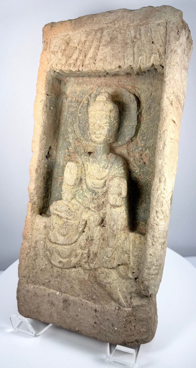 Early Chinese Buddhist devotional relief showing a seated Buddha with raised blessing gesture and circular halo