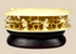 Front-facing view of a Chinese carved bone clam shell miniature with deep undercut interior figures on a dark wooden stand.