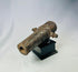 Rusted miniature iron cannon from the British Civil War period, mounted on a black display stand, featuring original trunnions and hollow barrel, 17th century.