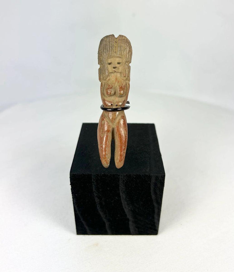 Molded terracotta figurine of seated female from Classic Veracruz culture, with vertical ridged headdress, bent legs, hands raised to face, incised facial features, and traces of red slip; mounted on black display stand; circa 600–900 CE, Gulf Coast of Mexico.
