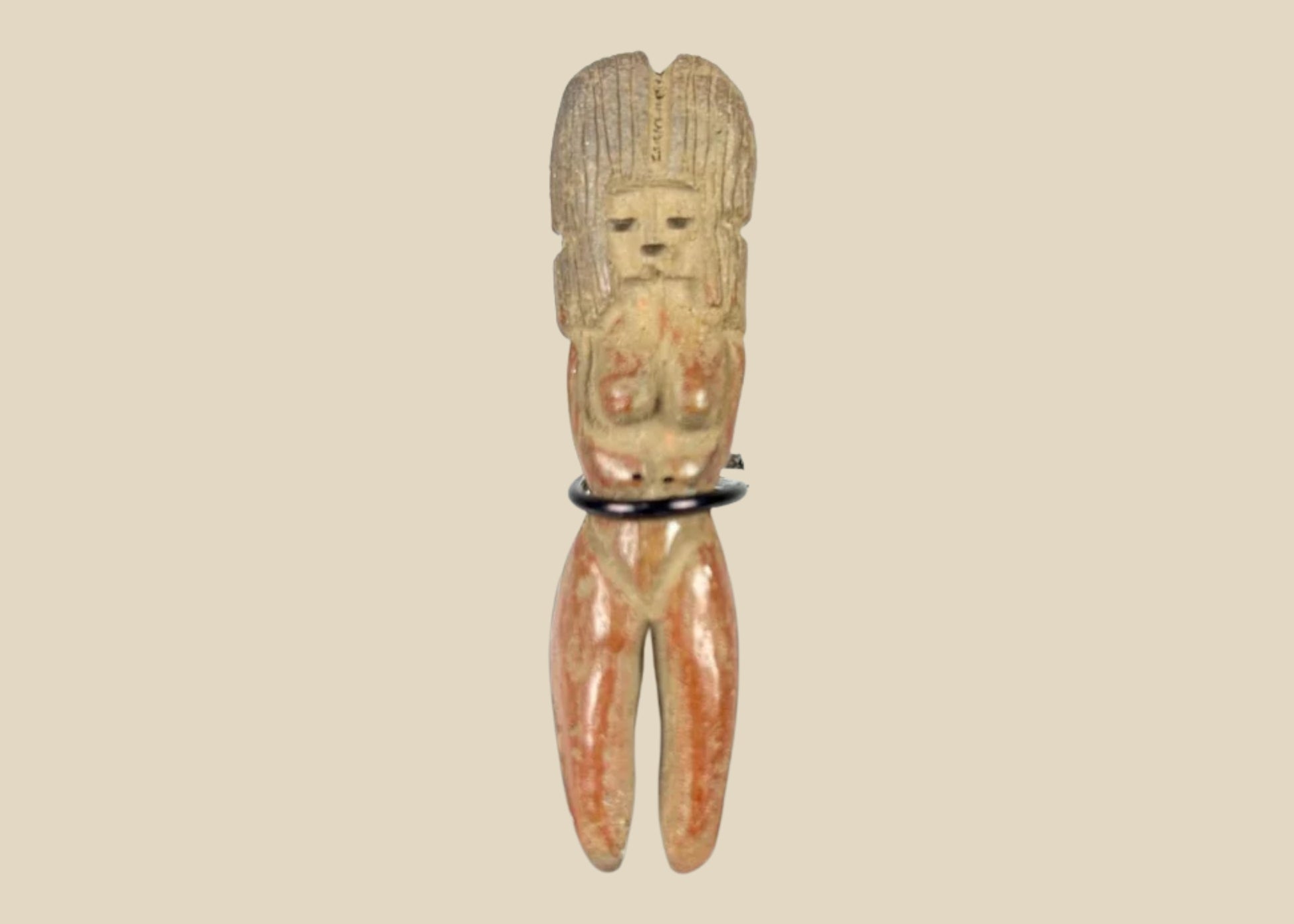 Molded terracotta figurine of seated female from Classic Veracruz culture, with vertical ridged headdress, bent legs, hands raised to face, incised facial features, and traces of red slip; mounted on black display stand; circa 600–900 CE, Gulf Coast of Mexico.