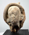 Historic Greek or Roman terracotta figure fragment showing its rounded sculptural form, facial details, and ancient surface texture.