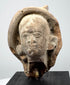Historic Greek or Roman terracotta figure fragment showing its rounded sculptural form, facial details, and ancient surface texture.