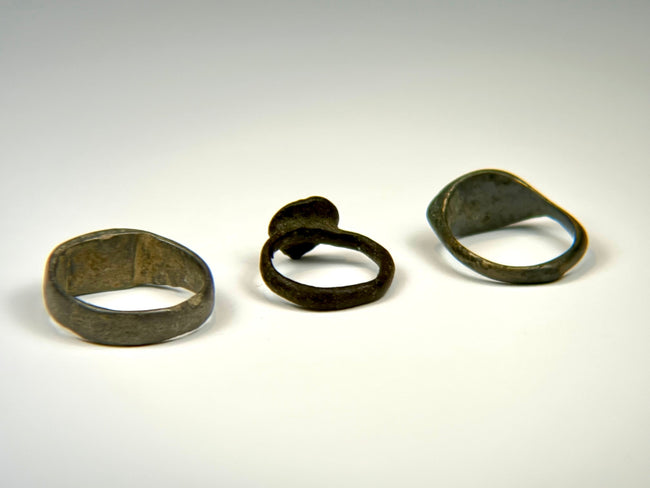 Ancient bronze finger ring collection showing three distinct bezel and band designs