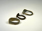 Three historic European bronze rings with engraved, shield-form, and plain band designs