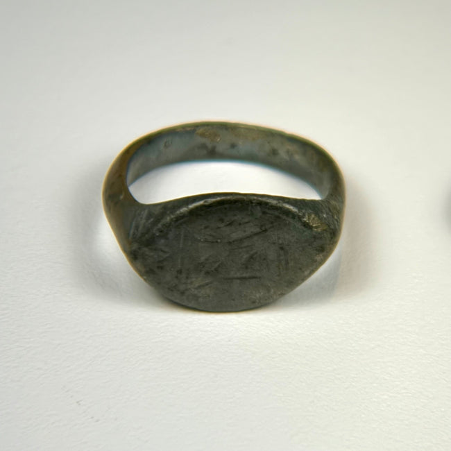 Ancient bronze oval signet ring with engraved bezel and deep olive patina, Roman to Early Medieval period