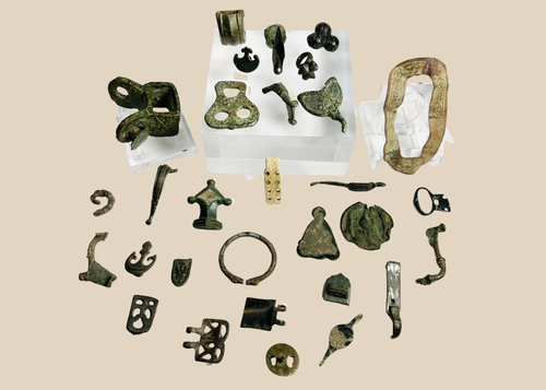 Collection of 31 ancient Roman bronze artifacts including belt mounts, harness fittings, buckles, spearhead fragment, and decorative mounts dating to the Roman Empire (1st–4th century CE