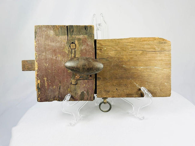 Colonial-era wooden locking mechanism with decorative forged iron backplate