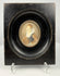 Frontal shot of 19th century miniature painting of woman in blue bodice
