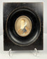Frontal shot of 19th century miniature painting of woman in blue bodice