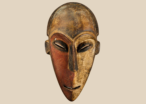 Authentic Dan tribal mask from Côte d’Ivoire, carved wood with dual-tone pigments, elongated eyes, and patina from ritual use, circa 1930–1950.