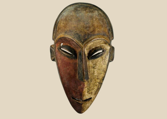 Authentic Dan tribal mask from Côte d’Ivoire, carved wood with dual-tone pigments, elongated eyes, and patina from ritual use, circa 1930–1950.