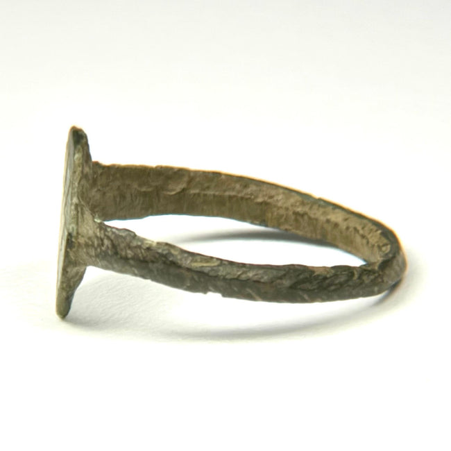Ancient bronze jewelry with engraved radiating bezel design, green mineralization, and aged patina