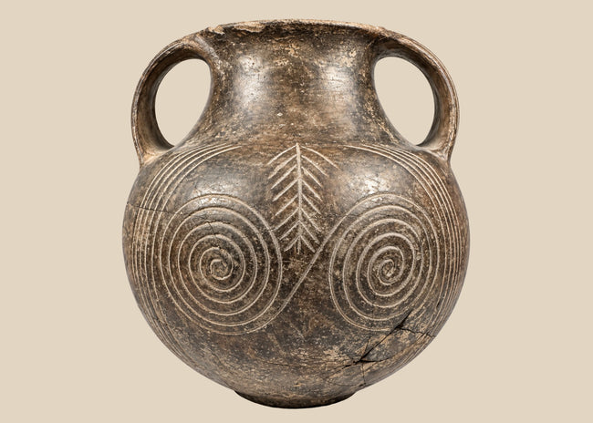 Early Etruscan impasto spiral amphora, circa 700–650 BCE, with double handles and deeply incised concentric decoration.