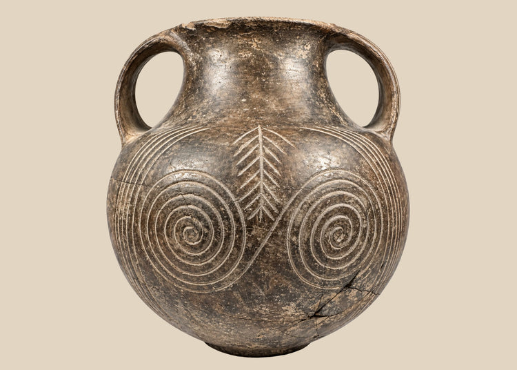 Early Etruscan impasto spiral amphora, circa 700–650 BCE, with double handles and deeply incised concentric decoration.