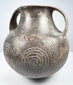 Upper angle of the Etruscan impasto vessel showing the open mouth, thick rim, twin handles, and incised decoration across the shoulder.