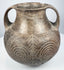 Early Etruscan impasto amphora with twin loop handles, flared rim, rounded body, and large incised spiral motifs across the front.