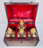 Open Georgian mahogany spirit box displaying four glass decanters, gilt decoration and rich red interior lining