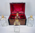 Four antique Georgian square glass spirit decanters with parcel-gilded decoration and matching glass stoppers