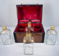 Four antique Georgian square glass spirit decanters with parcel-gilded decoration and matching glass stoppers