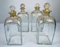 Georgian glass spirit decanters showing square bottle forms, gilt detailing and original fitted stoppers