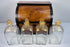 Antique Georgian boxed decanter set with mahogany case, four square glass spirit decanters and gilt stoppers