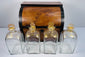 Antique Georgian boxed decanter set with mahogany case, four square glass spirit decanters and gilt stoppers