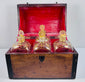 Georgian spirit box with four square glass decanters displayed beside the open mahogany carrying case
