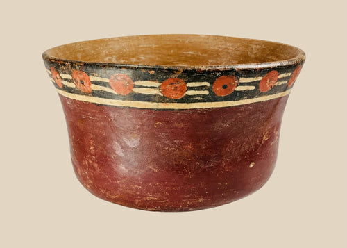 Early Nazca terracotta bowl, circa 100–300 AD, with flared rim and vibrant polychrome decoration of red circular and black-cream geometric motifs, reflecting pre-Columbian ceremonial artistry.