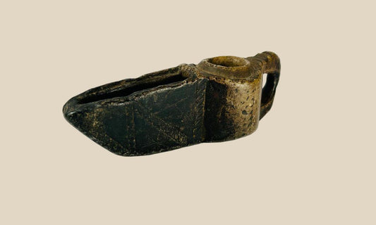 Ancient Islamic stone oil lamp from the early Islamic period (circa 7th–12th century CE). Hand-carved with geometric incised decoration, open spout for a wick, and natural patina. Reflects early Islamic artistry, domestic and ceremonial use, and cultural emphasis on geometric design and spiritual symbolism.