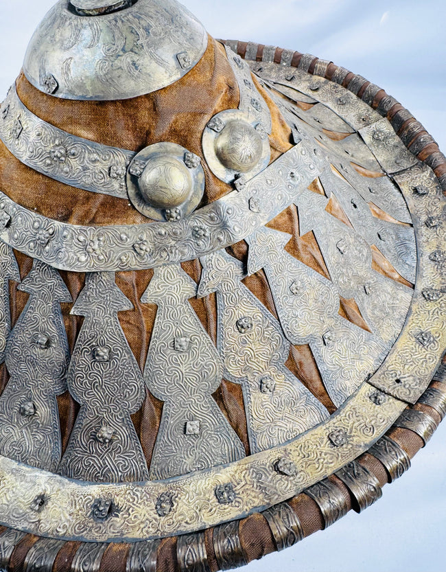 Close-up of engraved metal appliqués and velvet surface on an Ethiopian Ras shield