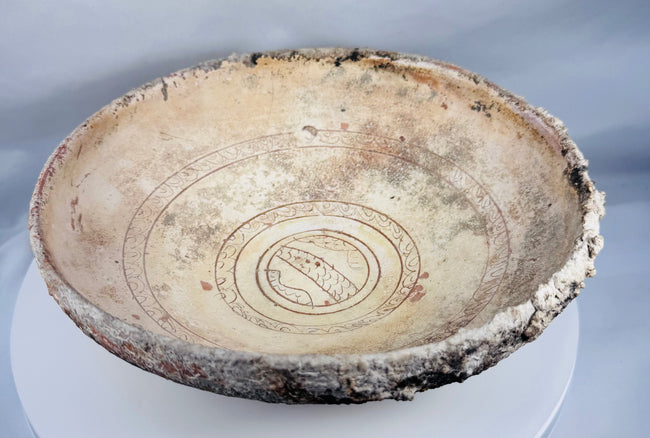 Ancient Byzantine earthenware bowl decorated with incised sgraffito patterns beneath a transparent lead glaze.