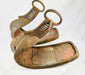 Antique Edo-period samurai stirrups with black and brown lacquer remnants and aged iron surfaces, shown as a matched pair.