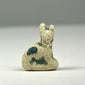 Ancient Egyptian faience cat amulet representing Bastet, with seated form and traces of blue-green glaze, circa 600–200 BCE.